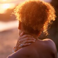 rear-view-of-woman-with-hand-on-neck-resized